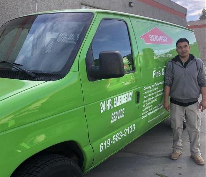 A photo of a man next to a van.