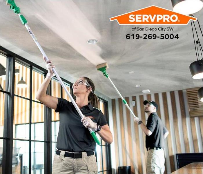 A SERVPRO technician is cleaning a soot-damaged ceiling.